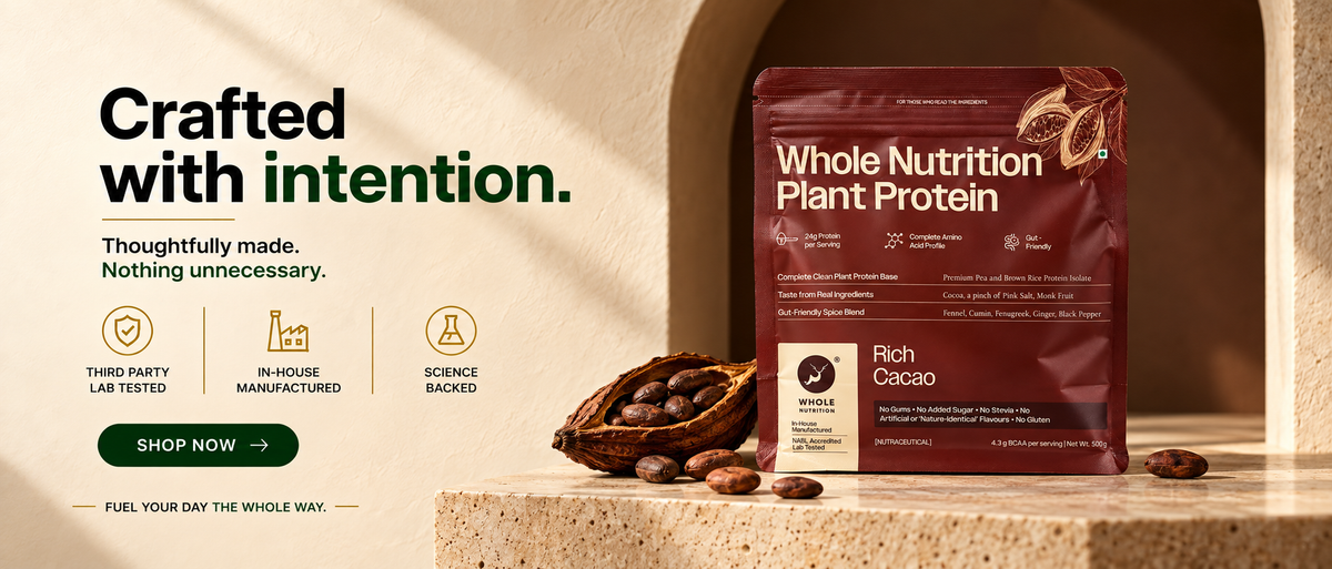 Whole Nutrition Rich Cacao Plant Protein pouch on a stone pedestal beside cocoa powder and beans, with the message “Crafted with intention